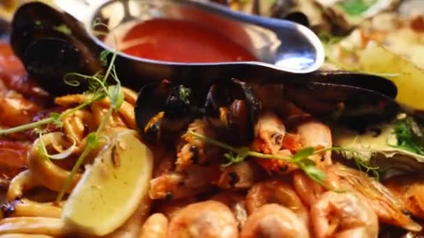 El conjunto de mariscos mixtos cocidos, camarones langosta, langostinos, mejillones, ostras y calamares se sirven en un plato grande de salver para los visitantes de restaurantes de lujo. Plato meditario tradicional girando en una bandeja. — Vídeo de stock