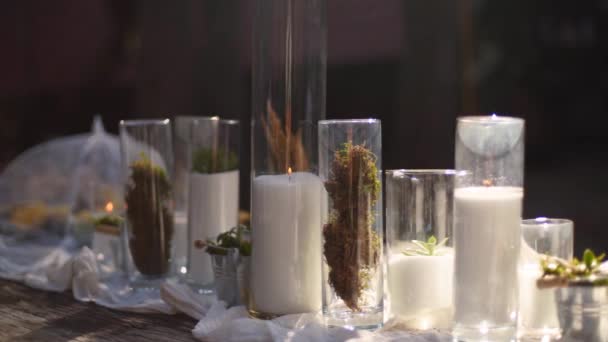 Bruiloft feest banket buiten in het bos. Eettafel ingericht in boho stijl met kaarsen, witte doek, bloemen, geserveerd met borden, servies, borden, maaltijden, servies en drankjes. Vakantie catering. — Stockvideo