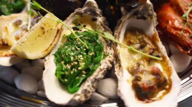 Lüks restoran ziyaretçileri için büyük bir tabakta pişirilmiş deniz ürünleri seti, ıstakoz karidesi, kral karidesi, midye, istiridye ve mürekkep balığı servis edilir. Bir tepside dönen geleneksel meditaryen yemek.