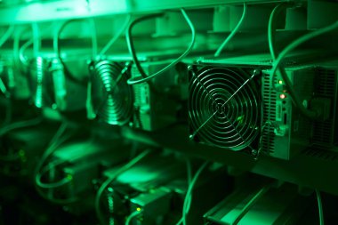 Bitcoin madencileri büyük çiftlikte. Kürsüdeki ASIC madencilik ekipmanları çelik konteynırdaki kripto para birimini rafa kaldırıyor. Entegre devre veri tabanında engelleme zinciri uygulaması. Sunucu odası ışıkları.