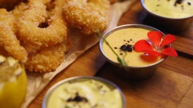 Kızarmış balık kompozisyonu sunuldu. Aşçı lüks Asya restoranında kalamar yüzükleri, lahanalar, istiridyeler ve istiridye yaptı. Kafede nefis atıştırmalıklar ve soslar.