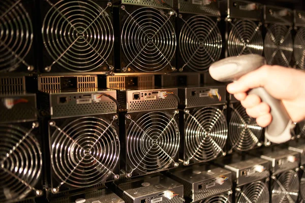 Controller in Uniform scannt ASIC Bitcoin Miners mit Barcode-Scanner im Lager. Lagerist bei der Arbeit im Lagerraum. Arbeiter scannt Barcodes von Netzteilen in Service-Reparaturzentrum. — Stockfoto