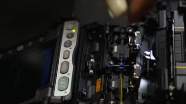 İşçi, optik hat kablosunu kaynak makinesiyle kaynaklıyor. Servis elemanı optik fiber lehim yapıyor. Optik fiber ve yönlendirici kablolarıyla sunucu odasında çalışan internet servis sağlayıcısı mühendisi..