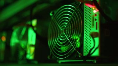 Bitcoin madencileri büyük çiftlikte. Kürsüdeki ASIC madencilik ekipmanları çelik konteynırdaki kripto para birimini rafa kaldırıyor. Engelleme teknolojisi. Güç kaynağı vantilatörleri ve ızgaralar. Sunucu odası ışıkları.