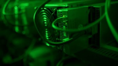Bitcoin madencileri büyük çiftlikte. Kürsüdeki ASIC madencilik ekipmanları çelik konteynırdaki kripto para birimini rafa kaldırıyor. Entegre devre veri tabanında engelleme zinciri uygulaması. Sunucu odası ışıkları.