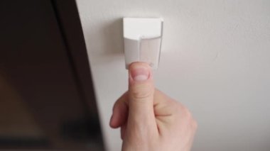 Parmağıyla kapı zili çalan biri. Adam birkaç kez kapı zili tuşuna basmış. Kurye kapıyı çalıyor..