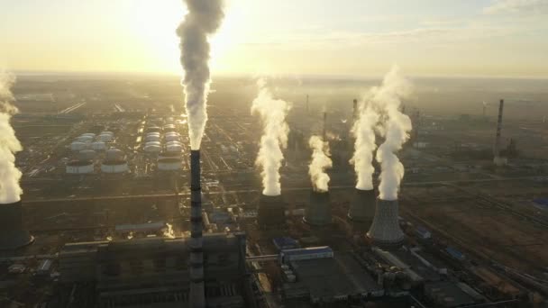 Luchtfoto van de thermische centrale. Drone vliegt over schoorsteen rookpijpen en koeltorens van industrieel gebied bij zonsondergang. Thermische elektriciteitscentrale van bovenaf zuigt de luchtemissies uit. — Stockvideo