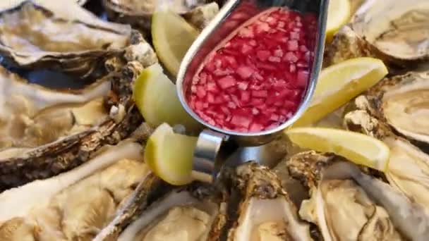 Vassoio di ostriche fresche servite sul ghiaccio con limone che ruota su un grande piatto di salver per i visitatori del ristorante di lusso. Piatto tradizionale meditariano set di frutti di mare per buongustai. — Video Stock