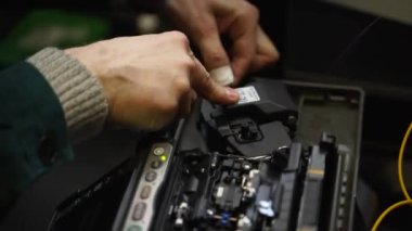 İşçi, optik hat kablosunu kaynak makinesiyle kaynaklıyor. Servis elemanı optik fiber lehim yapıyor. Optik fiber ve yönlendirici kablolarıyla sunucu odasında çalışan internet servis sağlayıcısı mühendisi..