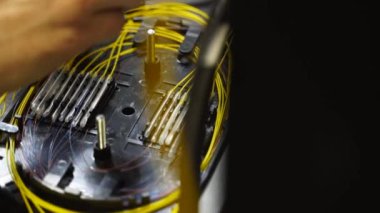 İşçi, optik hat kablosunu kaynak makinesiyle kaynaklıyor. Servis elemanı optik fiber lehim yapıyor. Optik fiber ve yönlendirici kablolarıyla sunucu odasında çalışan internet servis sağlayıcısı mühendisi..