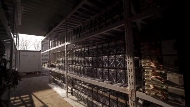 Bitcoin ASIC miners in warehouse. ASIC mining equipment on stand racks for mining cryptocurrency in steel container. Blockchain techology application specific integrated circuit units storage. — Stock Video