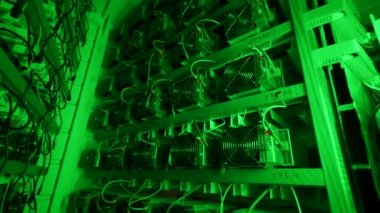 Bitcoin madencileri büyük çiftlikte. Kürsüdeki ASIC madencilik ekipmanları çelik konteynırdaki kripto para birimini rafa kaldırıyor. Entegre devre veri tabanında engelleme zinciri uygulaması. Sunucu odası ışıkları.