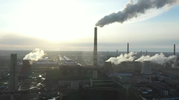 Luchtfoto van de thermische centrale. Drone vliegt over schoorsteen rookpijpen en koeltorens van industrieel gebied bij zonsondergang. Thermische elektriciteitscentrale van bovenaf zuigt de luchtemissies uit. — Stockvideo