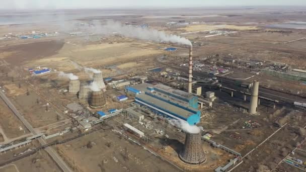 Vista aérea da central térmica. O drone voa sobre os tubos de fumaça da chaminé e as torres de refrigeração da área industrial no por do sol. Estação térmica de geração de eletricidade de cima esgota as emissões atmosféricas. — Vídeo de Stock