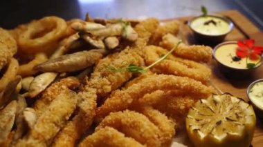 Şef, kızarmış balıkla mikro yeşillik karışımı karışımı servis ediyor. Aşçı kalamar halkalarına, lahanalara, kemirgenlere, istiridyeleri lüks Asya restoranındaki tepsiye koyar. Kafede nefis atıştırmalıklar ve soslar.