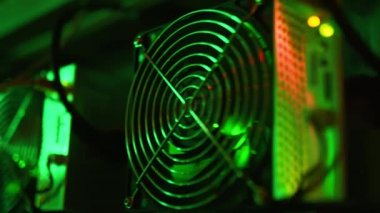Bitcoin madencileri büyük çiftlikte. Kürsüdeki ASIC madencilik ekipmanları çelik konteynırdaki kripto para birimini rafa kaldırıyor. Engelleme teknolojisi. Güç kaynağı vantilatörleri ve ızgaralar. Sunucu odası ışıkları.