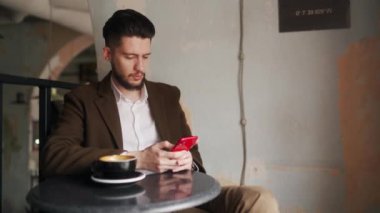 Kafede otururken akıllı telefon kullanan klas bir genç. Tabuttaki sosyal ağ uygulamasına bakan bir adam. Ofis çalışanı molada bir fincan kahveyle dinleniyor. İç mekan.