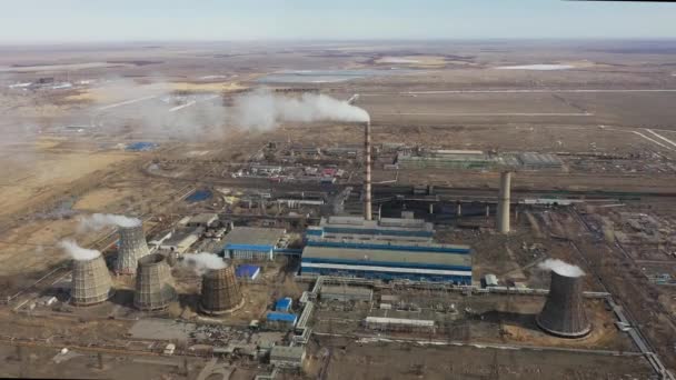 Aerial view of thermal power plant. Drone flies over chimney smoke pipes and cooling towers of industrial area on sunset. Thermal electricity generation station from above exhausts air emissions. — Stock Video
