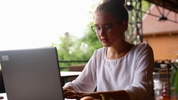 Perempuan muda ras campuran bekerja dengan laptop di kafe di lokasi tropis. Wanita Kaukasia Asia belajar menggunakan internet. Wanita bisnis melakukan pekerjaan pemasaran sosial dan belanja. Konsep telecommuting . — Stok Video