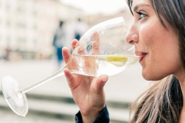 Woman drinking an aperitif clipart