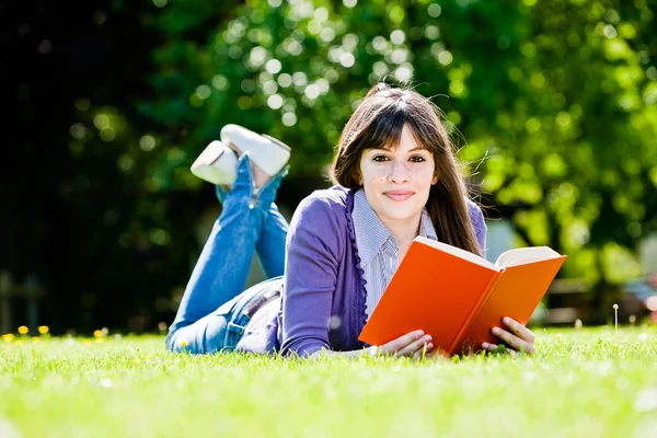 Ung kvinne som leser en bok – stockfoto