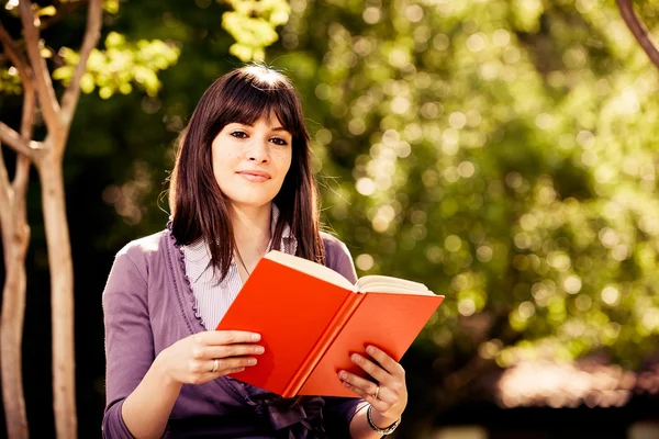 Kvinne som leser en bok – stockfoto