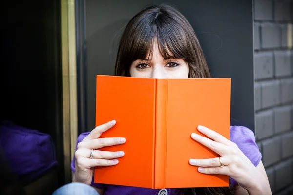 Woman covers her face with a book — Stock Photo, Image