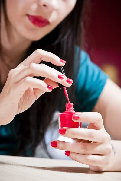 Woman painting her fingernails.