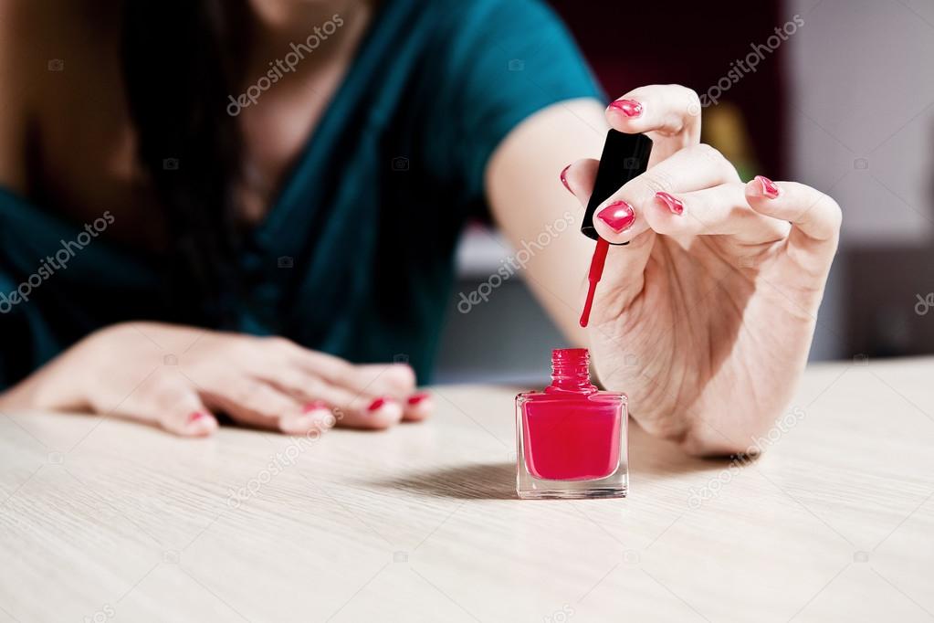 Woman painting her fingernails.
