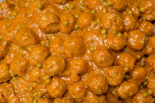 Background of meatballs with brown sauce and green peas — Stock Photo, Image