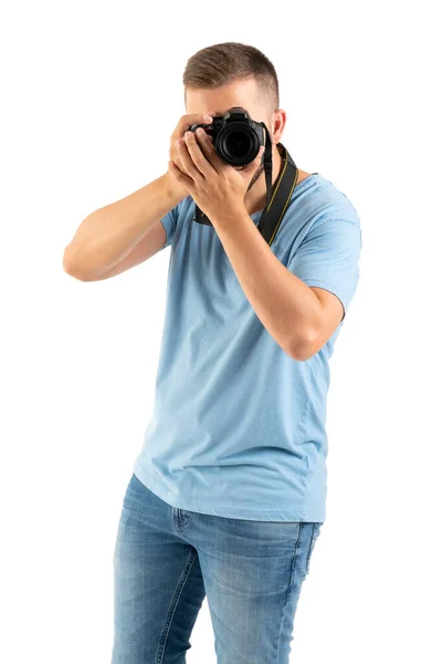 A young man with a black camera isolated on a white background — Stock Photo, Image