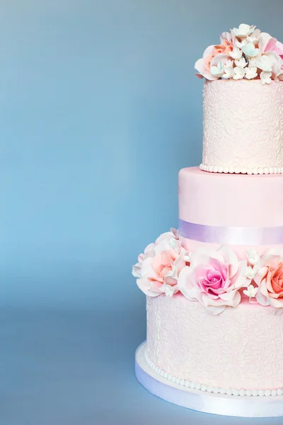 Cake decorated with flowers on a blue background — Stock Photo, Image