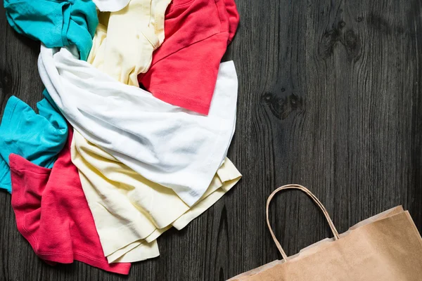 Neatly folded clothes and a paper bag — Stock Photo, Image