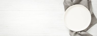 Ahşap masada beyaz boş tabakla afiş.