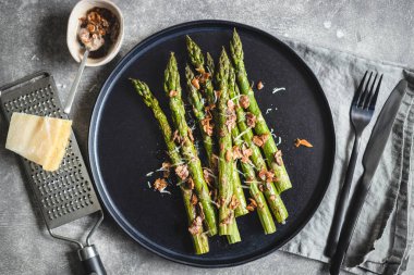 Badem fıstıklı kuşkonmaz ve siyah tabakta peynir..