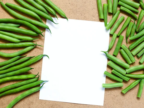 Zelené fazole a nakrájené zelené fazolky na stůl s bílou knihu — Stock fotografie