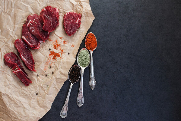 Steak of beef on paper and spices