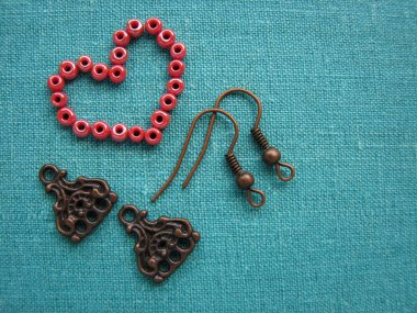 Kalp, küpe, el yapımı takı yapma şeklinde kırmızı boncuklar