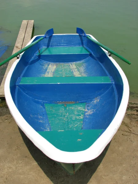 Barca blu con remi sulla riva — Foto Stock