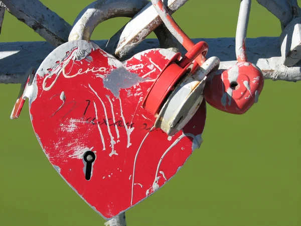 Serratura nuziale a forma di cuore rosso con un buco della serratura sulla ringhiera del ponte — Foto Stock