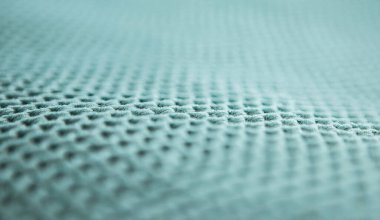 Rahat bir ekoseye basit desenler örülmüş, arka planda bulanık mavi örgü dokular, örgü örme, yaratıcılık, dikiş işi, yan görünüş, yakın çekim, alan derinliği, bulanıklığı, perspektif