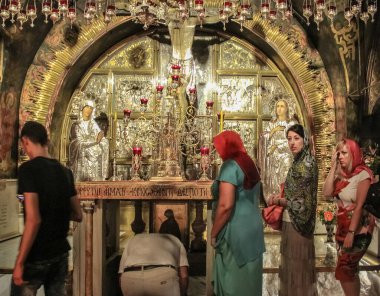 Kudüs, İsrail - 14 Temmuz 2015. Kutsal Mezar Kilisesi 'nde İsa' nın çarmıha gerildiği yerde (İsa 'nın dirilişi tapınağında) inananlar ibadet ederler.).