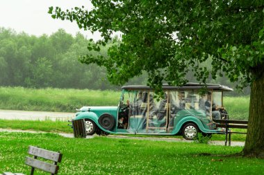 Büyüleyici bir araç, ziyaretçilerin doğal manzara boyunca eşsiz bir turun keyfini çıkardıkları yemyeşil bir parkta park halinde görülüyor.. 