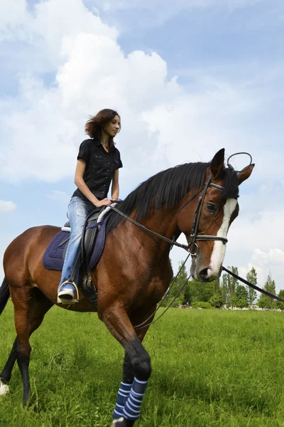 Una chica en un caballo, montar a caballo para principiantes — Foto de Stock