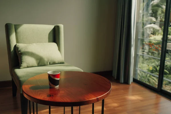 Чашка горячего напитка на столе с зеленым стулом в классическом уютном баре. — стоковое фото