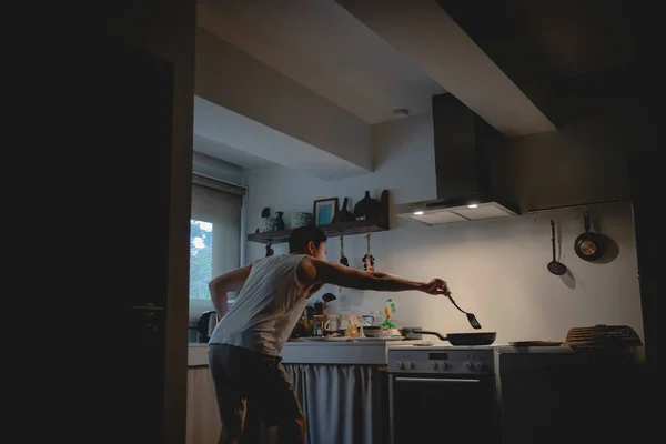 Homem está cozinhando jantar na cozinha. — Fotografia de Stock