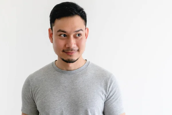 Asiatischer Mann im grauen T-Shirt blickt auf den leeren Raum auf isoliertem E-Hintergrund. — Stockfoto