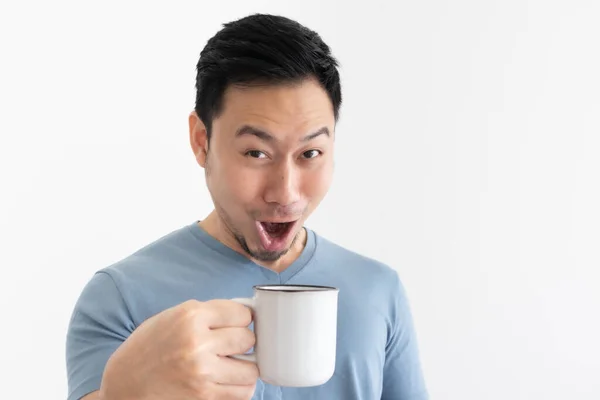 Funny wow face of man in blue t-shirt drinks coffee from white mug. — Stock Photo, Image
