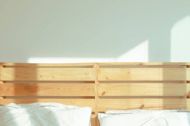 Tavan arası beyaz yatak odası, yumuşak güneş ışığı, kış sabahı..