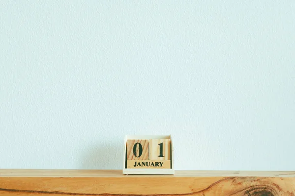 Piezas de madera con texto 01 ENERO en pared blanca. —  Fotos de Stock